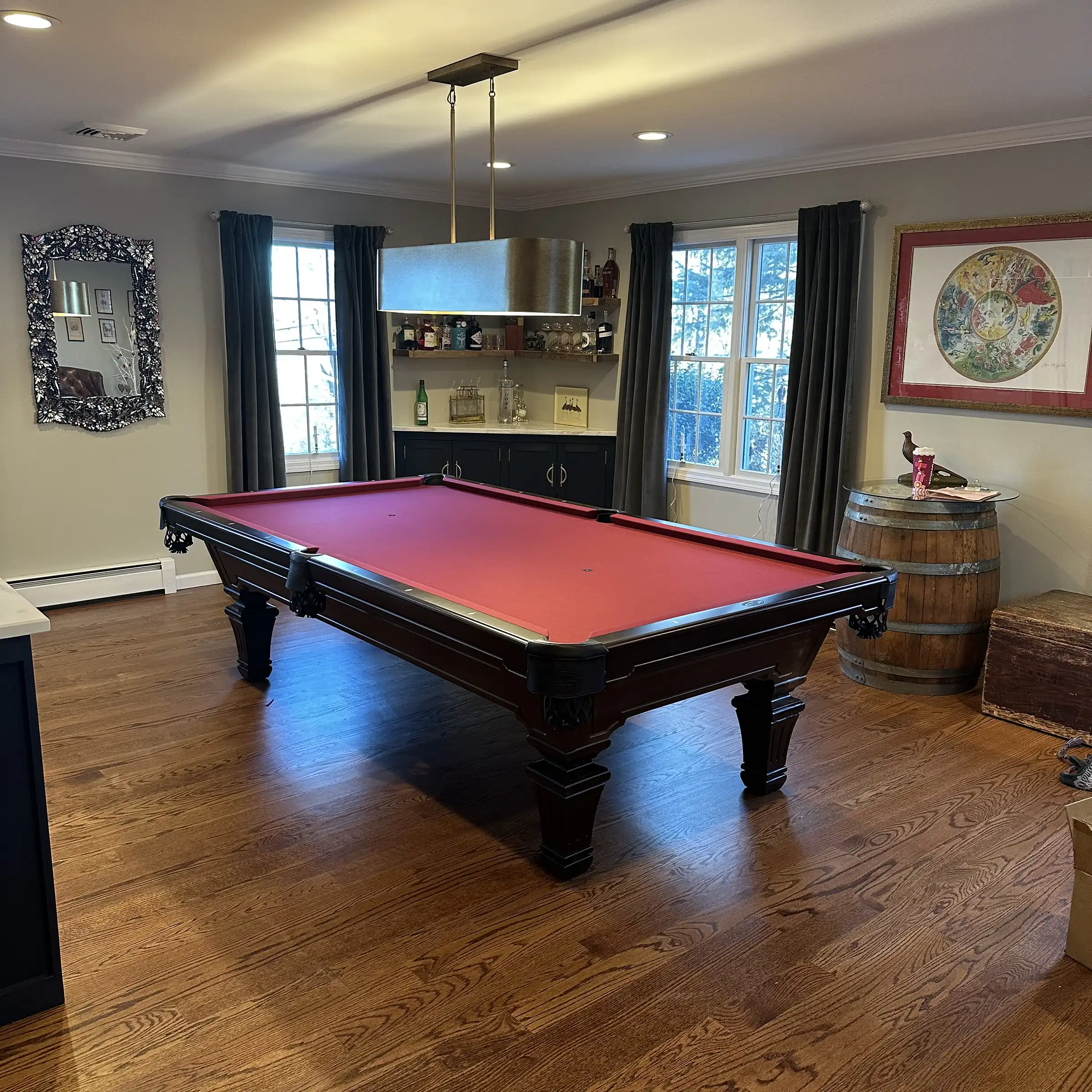 Olhausen Hampton pool table with a rich, dark wood finish and vibrant red felt in a stylishly decorated game room. 