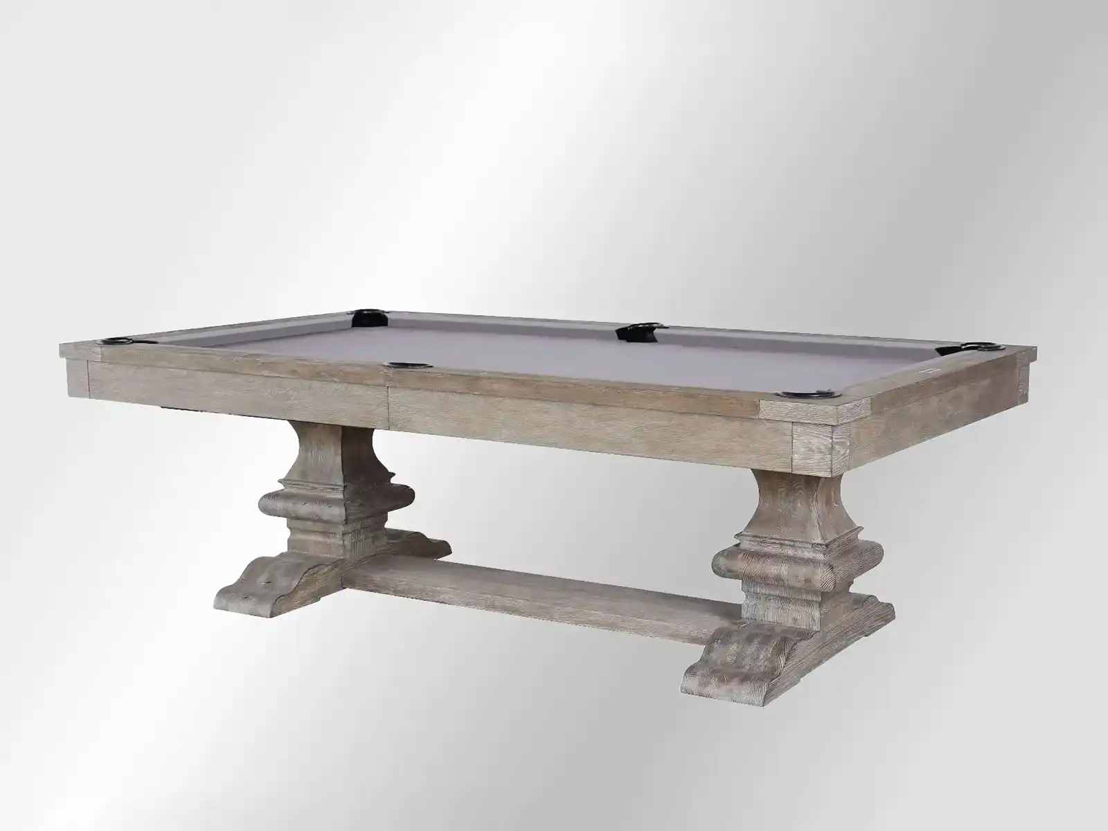 Plank and Hide 8' Beaumont Pool Table w/ Dining Top. A rustic-style pool table with a light gray wood finish and a matching felt surface, featuring ornate pedestal legs and black corner pockets.