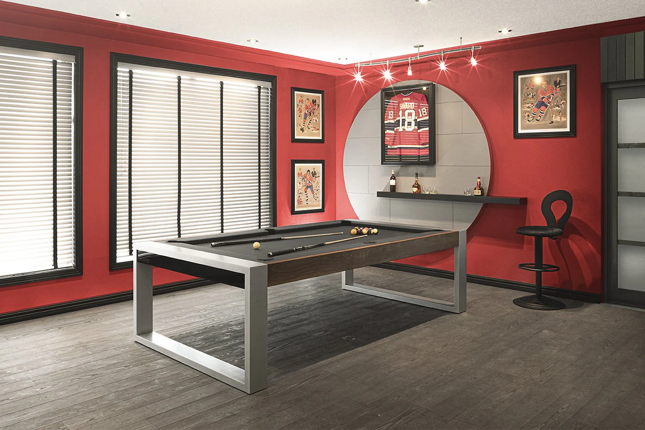 Canada Billiards 8' Revolution Pool Table with a gray frame and brown felt, positioned in a room with red walls, white blinds, and sports memorabilia on display.