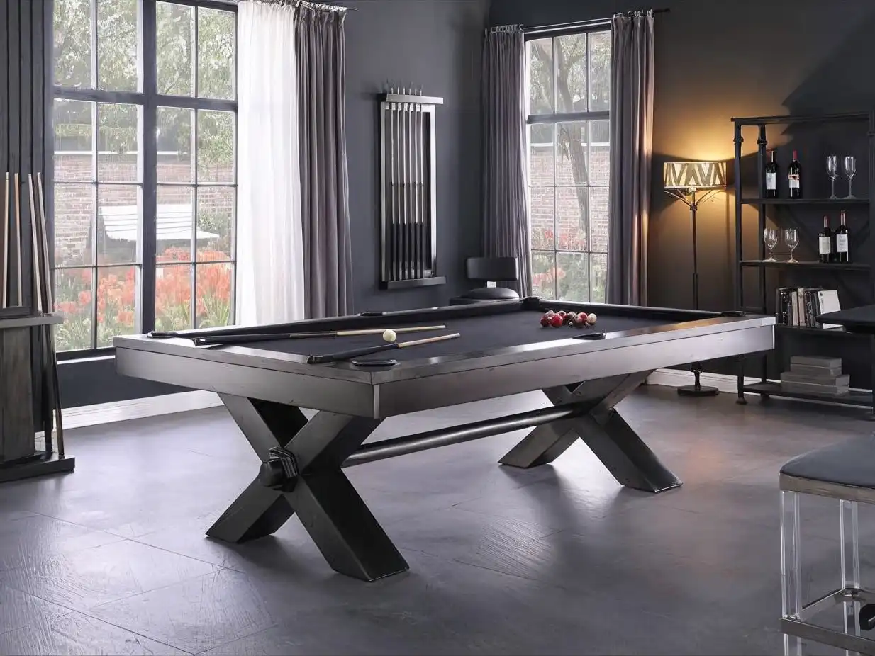 Plank and Hide 8' Vox Pool Table with a dark gray finish and black felt, featuring a modern X-shaped leg design in a room with large windows.