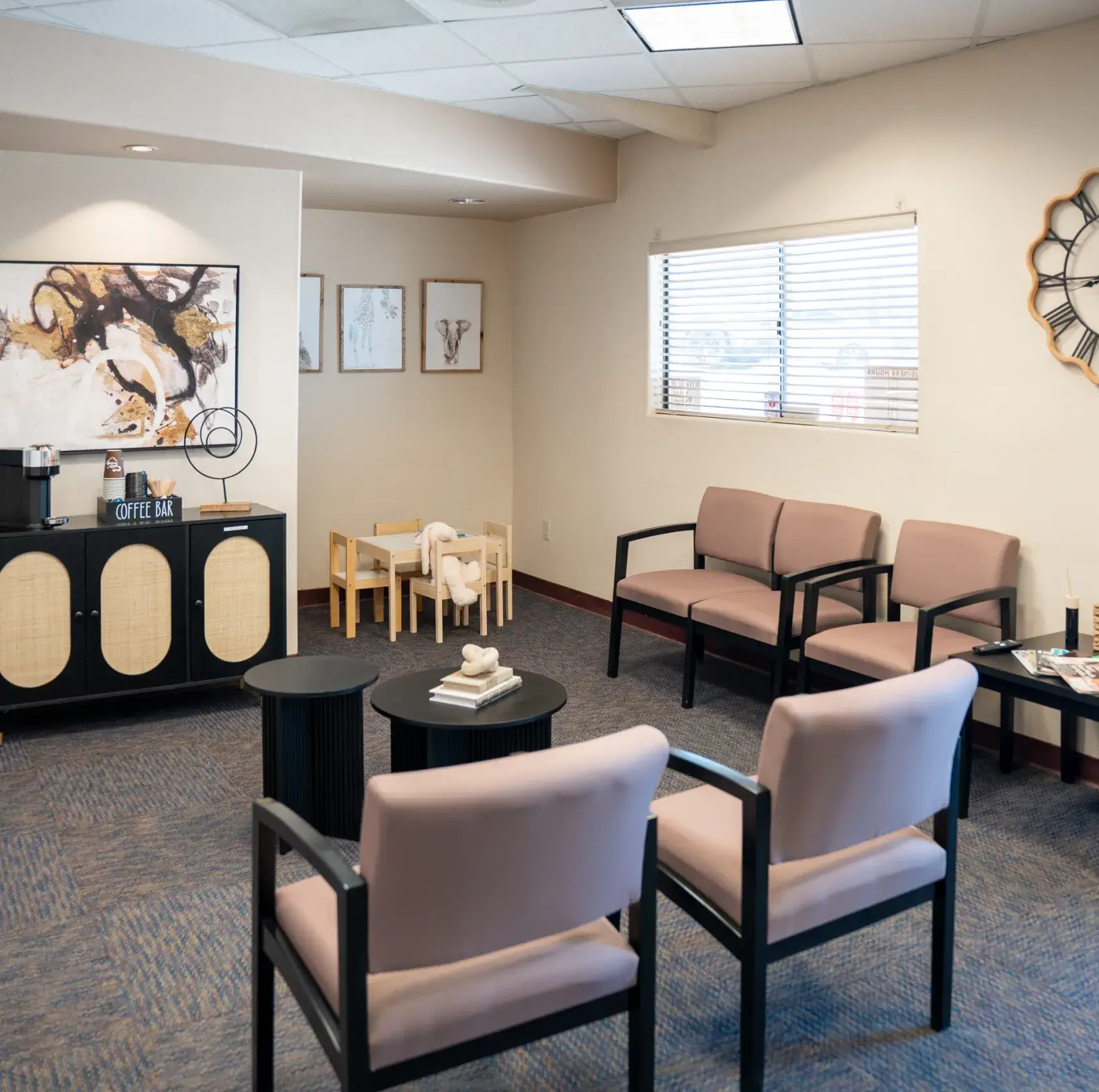 A waiting room with chairs, a children's play area, and a coffee bar.