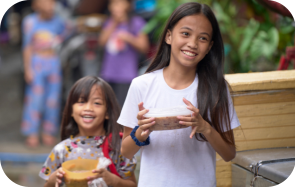 Smiling children hold goods while walking in public