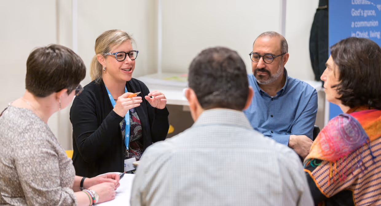 Small group of adults engaged in discussion during a meeting