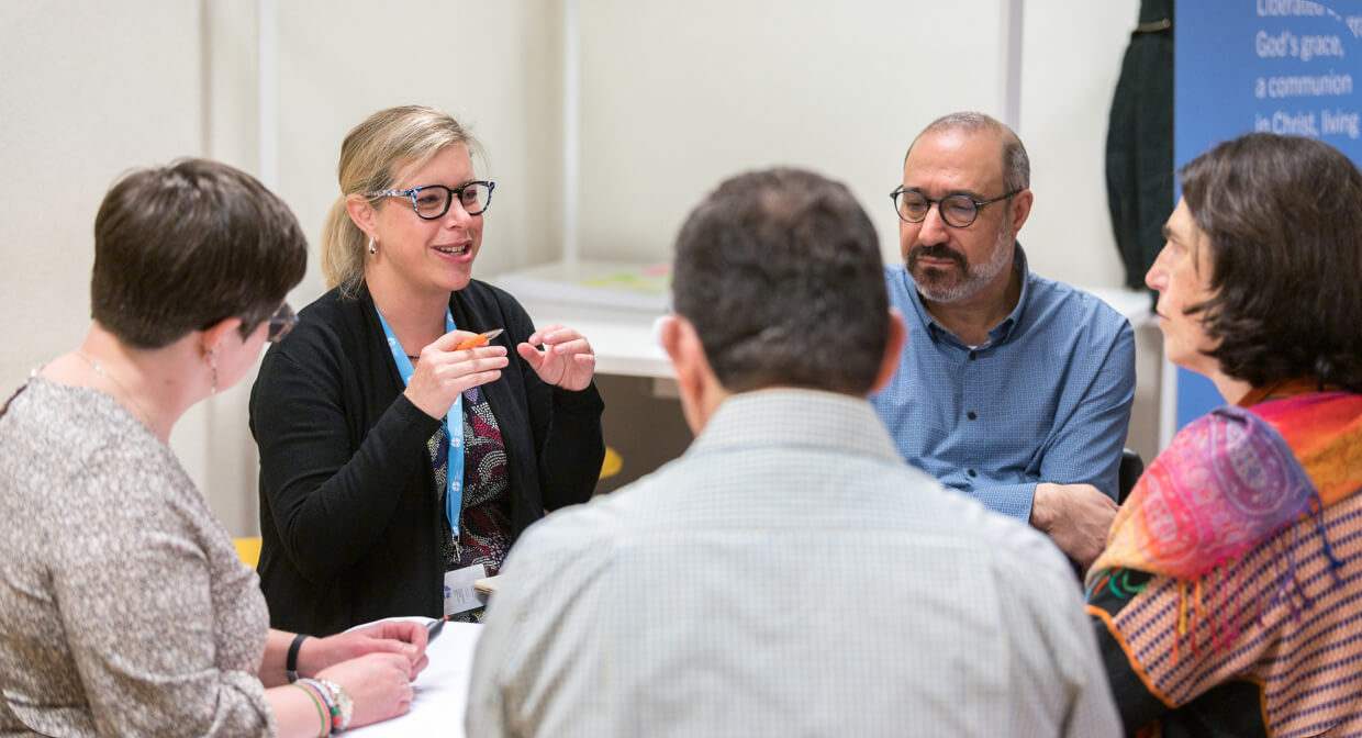 Small group of adults engaged in discussion during a meeting