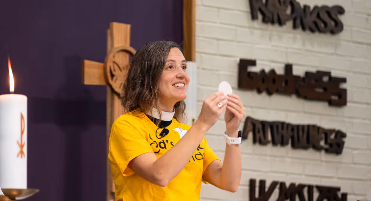 Clergy member holding communion bread during a church service