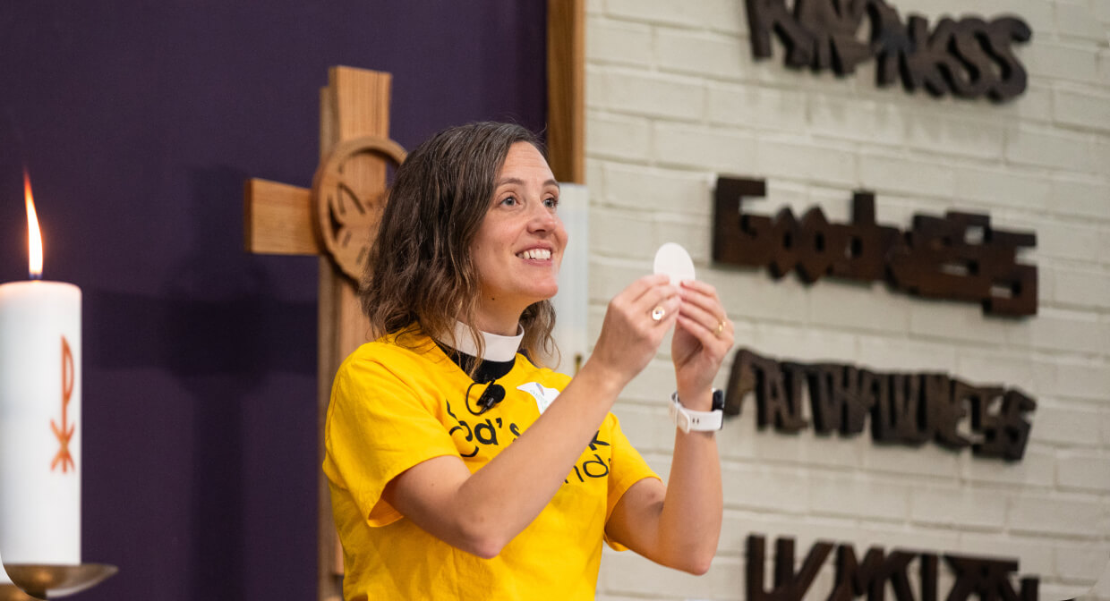 Clergy member holding communion bread during a church service