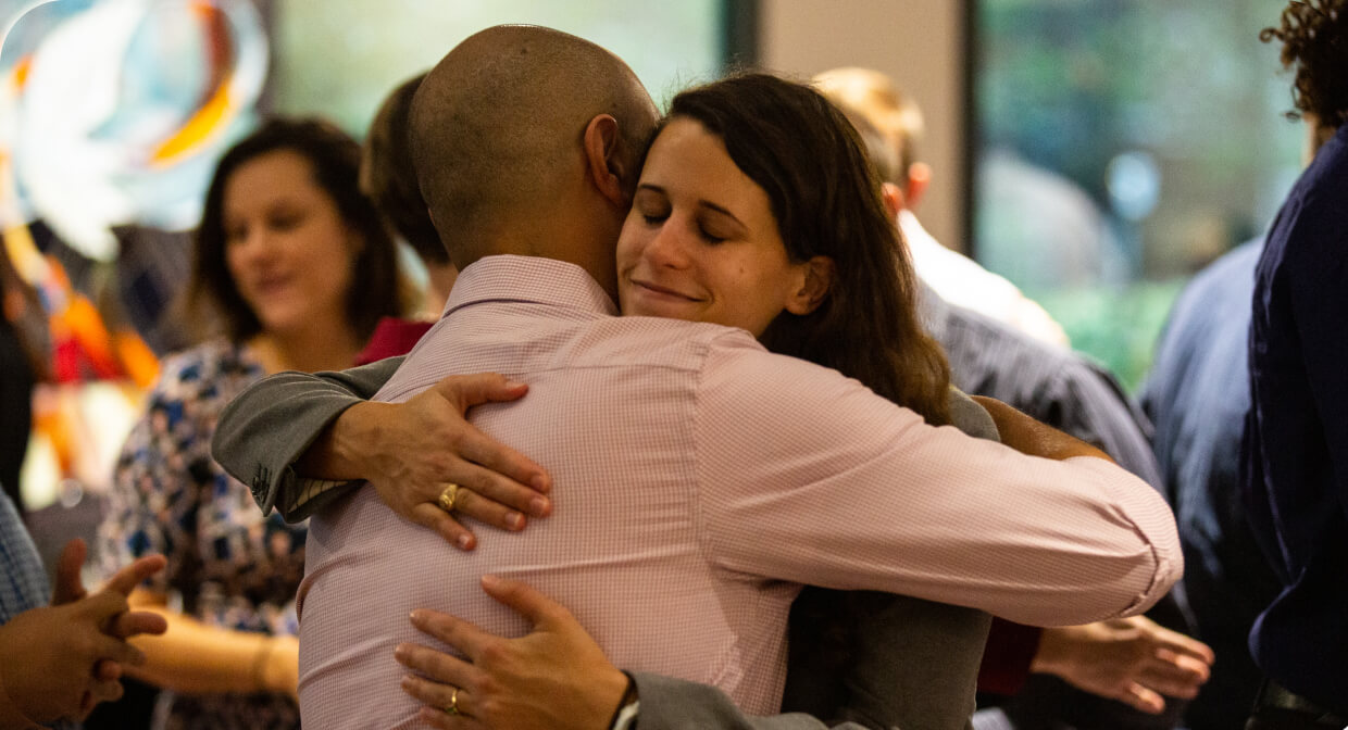 Two people sharing a welcoming hug at a church gathering