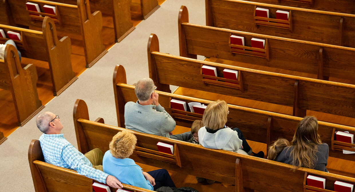 People seated in church pews during a service