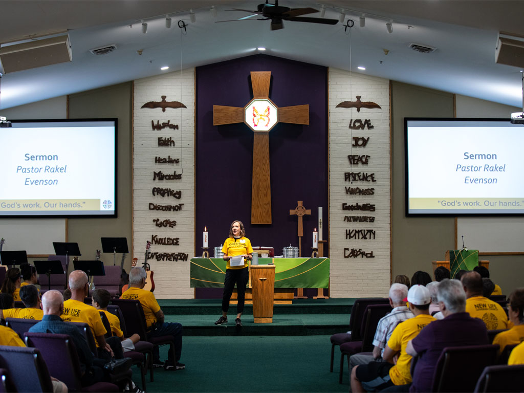 Worship leader speaking from a pulpit during a church service