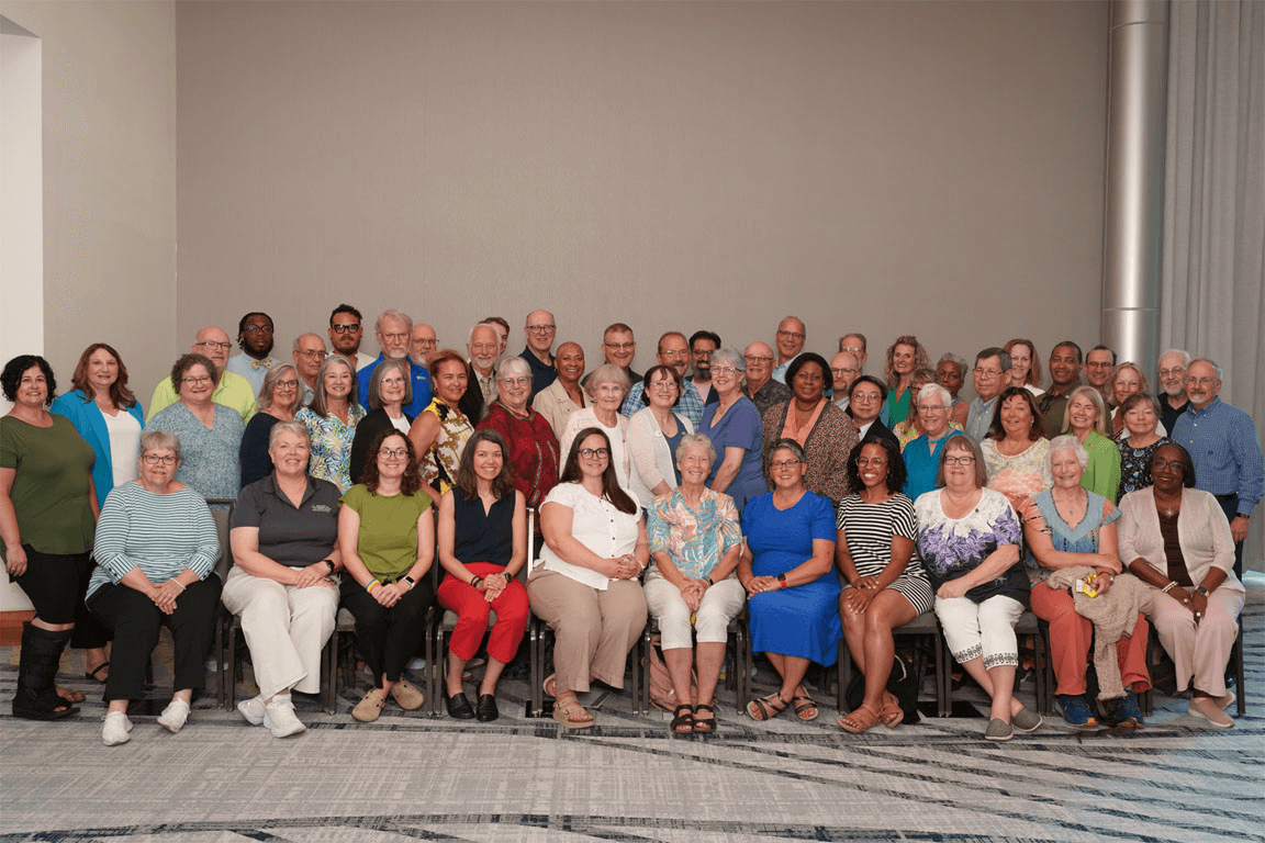Group photo of 60 people seated and standing in rows, all of them serving as secretaries of Synods within the ELCA.