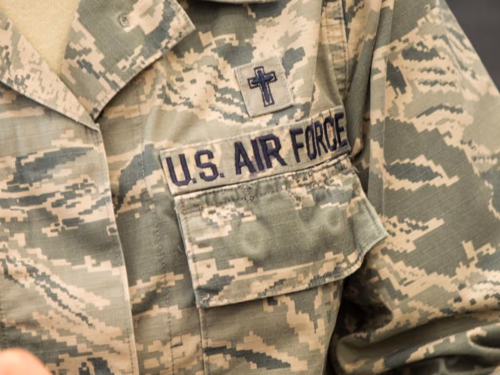 Close-up of a US Air Force camouflage unform with a small cross above the pocket.