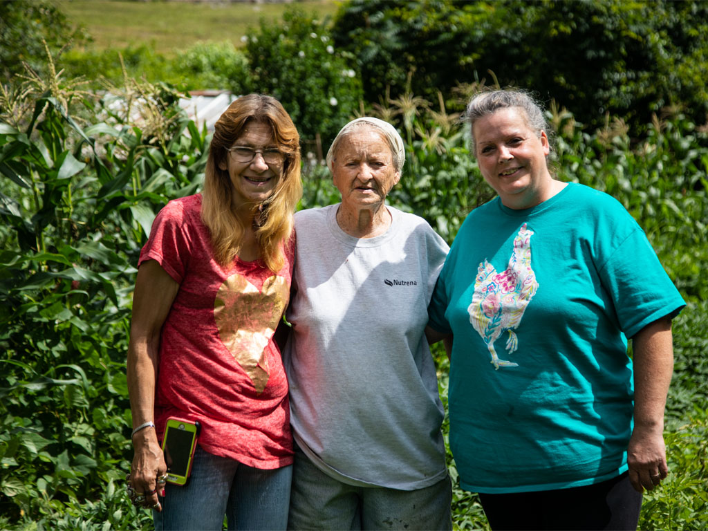 Three people standing together outdoors and smiling