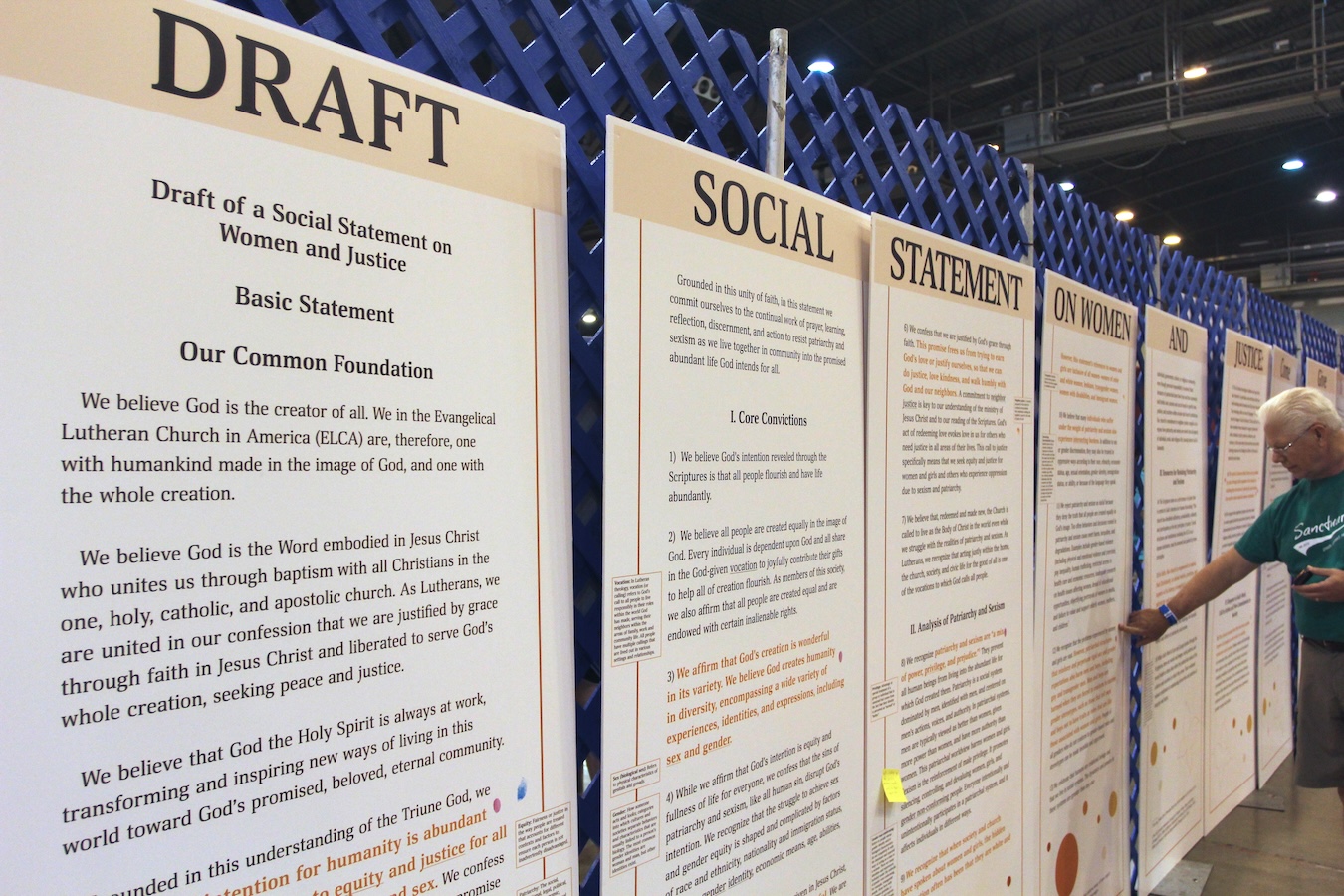 Large posterboards hang on a wall; the five visible boards carry headings that read “Draft Social Statement on Women.”