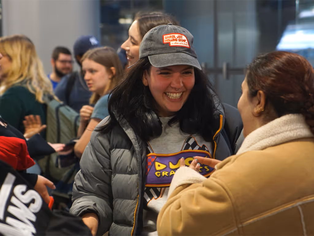 Two people smiling and talking in a busy indoor space