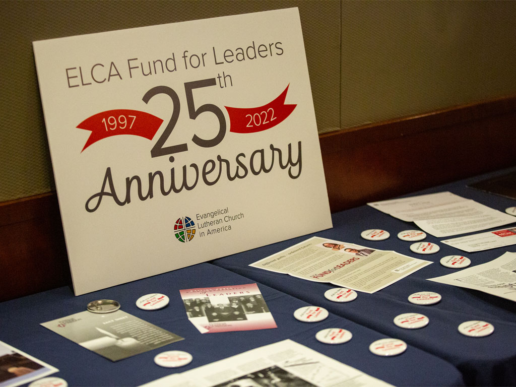 Table display with printed materials and a sign reading 25th Anniversary