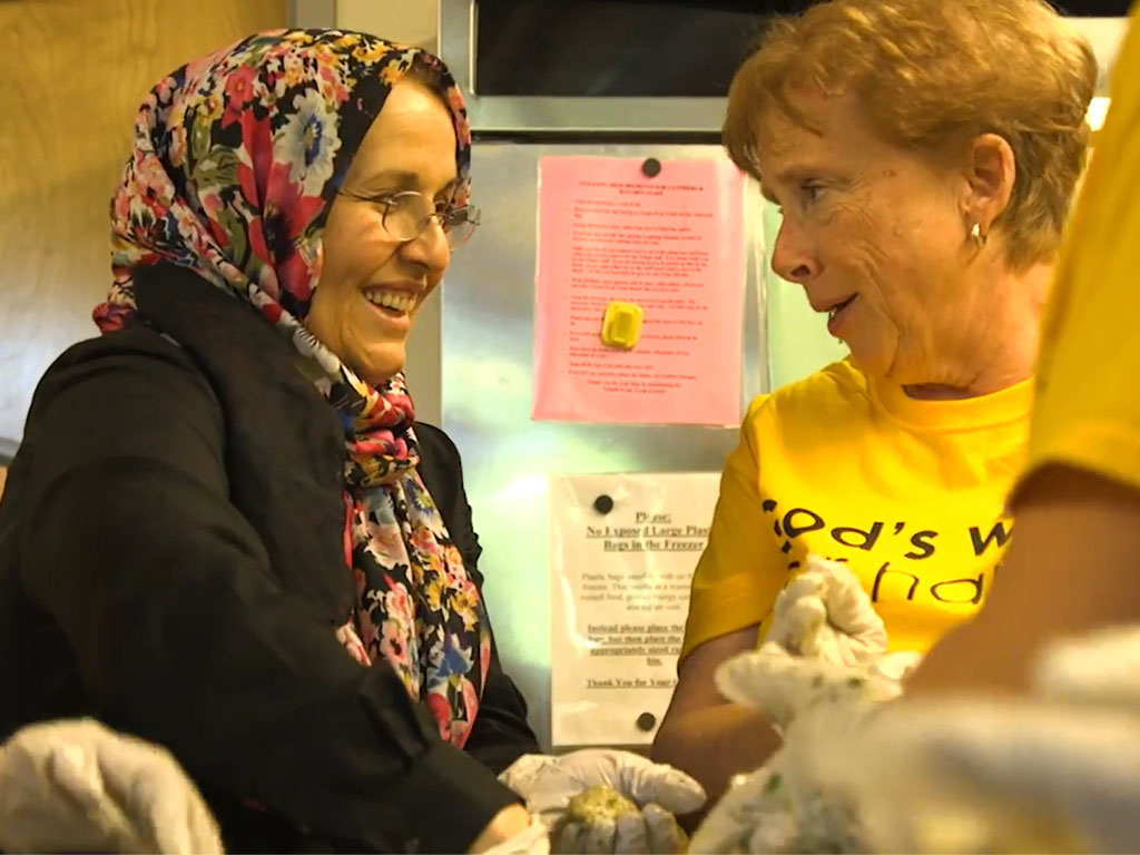 Two people smiling and talking together indoors
