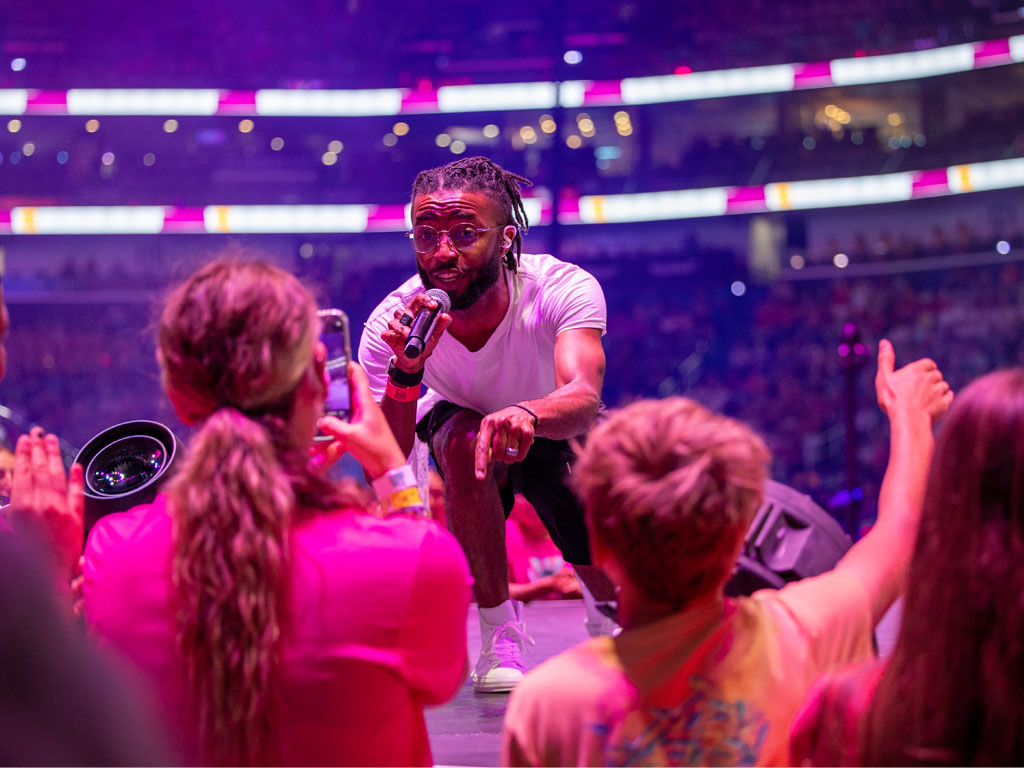 Performer on stage with young people gathered in front