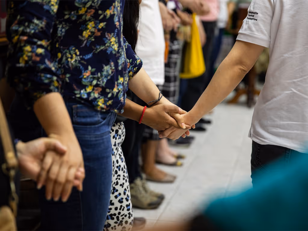 A black sign with pink-purple writing reads “Tuesdays in Black”; underneath this, white text reads “Toward a world without rape and violence.”