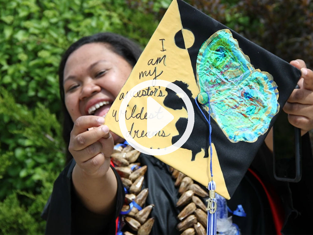 Person holding a handmade art piece with text and colorful decorations