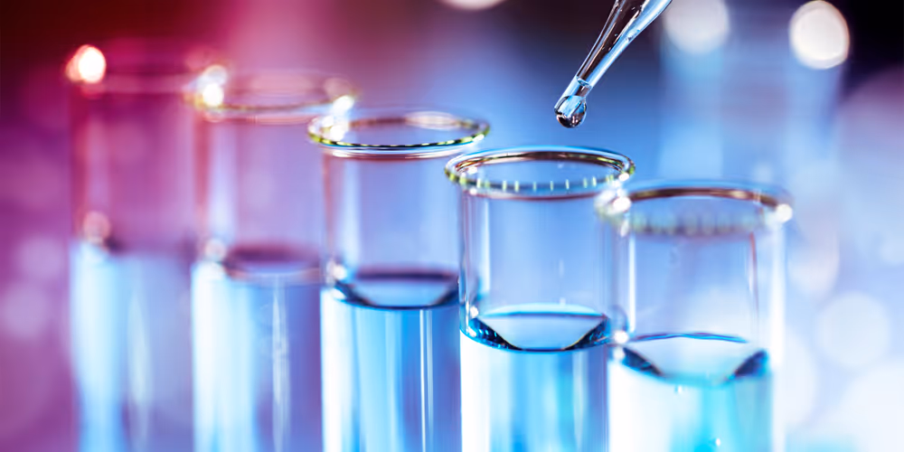 Two rows of lighted candles in glass jars sit on an altar with a blurred background.