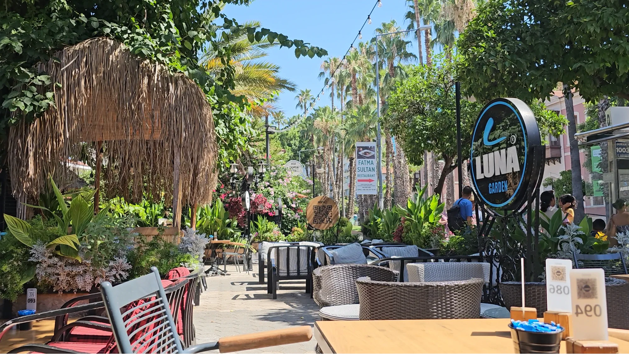 Outdoor garden seating at Luna Garden Restaurant in Antalya surrounded by tropical greenery