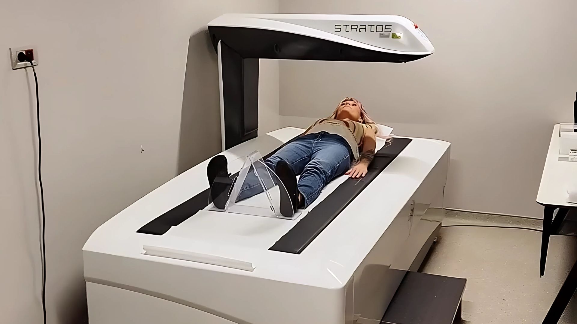 A woman lying on a Stratos body composition scanner at a medical facility in Istanbul during a health checkup session.