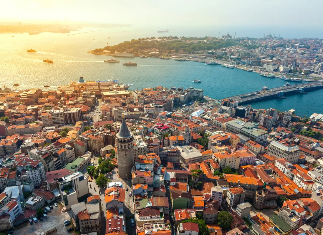 Aerial view of Istanbul’s Galata Tower with the Golden Horn and Bosphorus in the background at sunset.