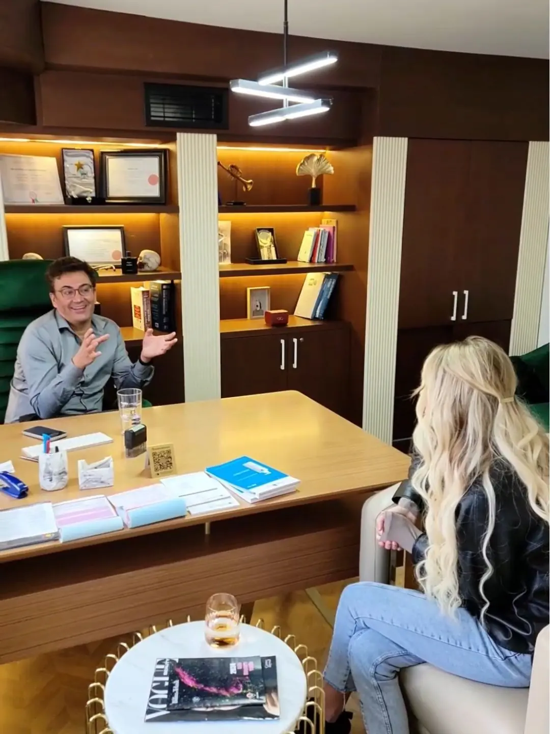 Woman with long blonde hair consulting with a cosmetic doctor in his office in Istanbul, discussing aesthetic treatment options.