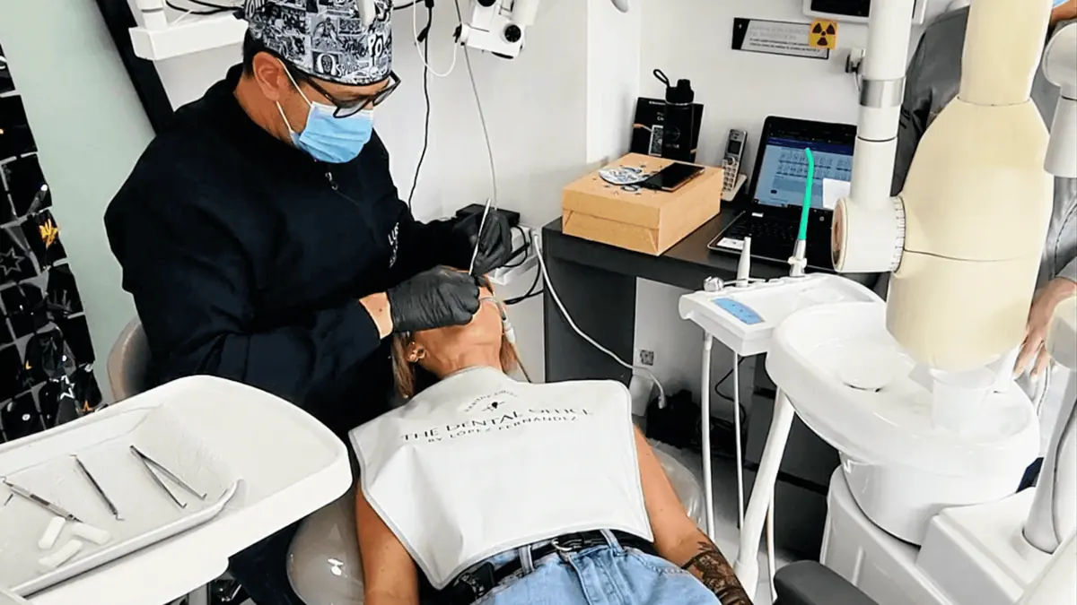 A dentist in Medellín performing a dental procedure on a patient at a modern clinic.