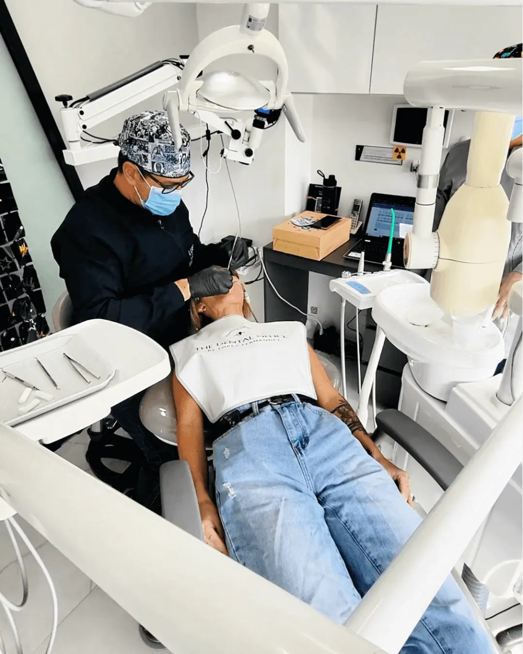 A dentist performing a dental procedure on a patient at The Dental Office in Medellín, Colombia.