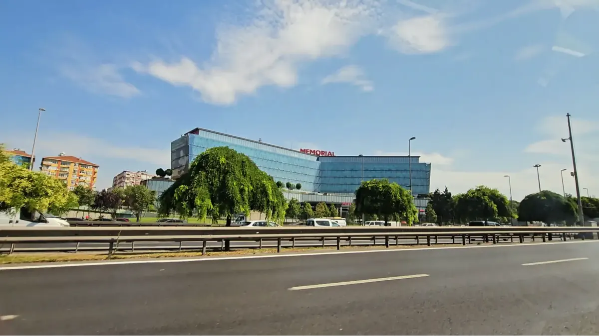 Exterior view of Memorial Bahçelievler Hospital in Istanbul, Turkey, with modern glass architecture and surrounding greenery.