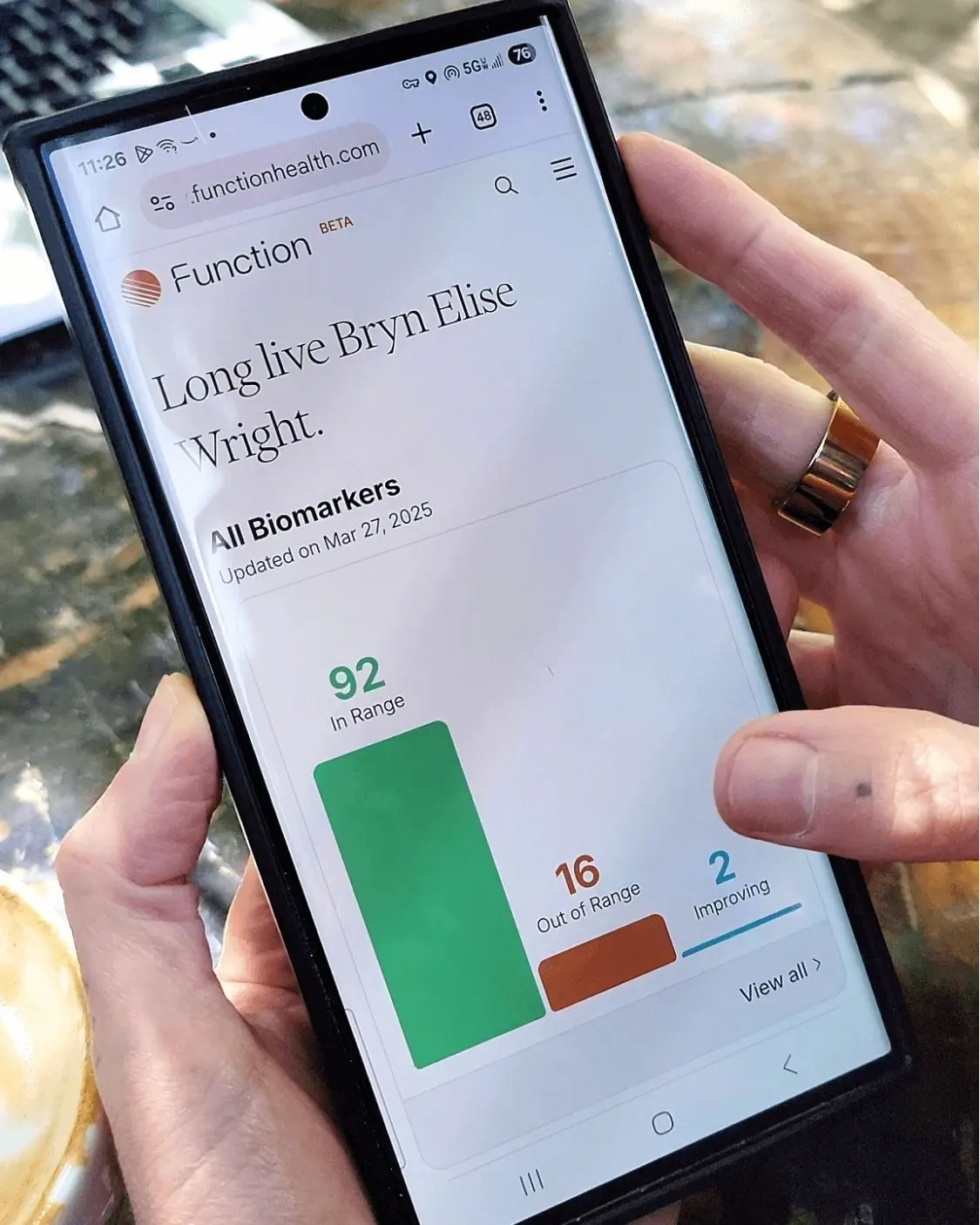 Smartphone screen showing Function Health biomarker dashboard with 92 results in range, 16 out of range, and 2 improving, highlighting personalized health tracking and diagnostics.