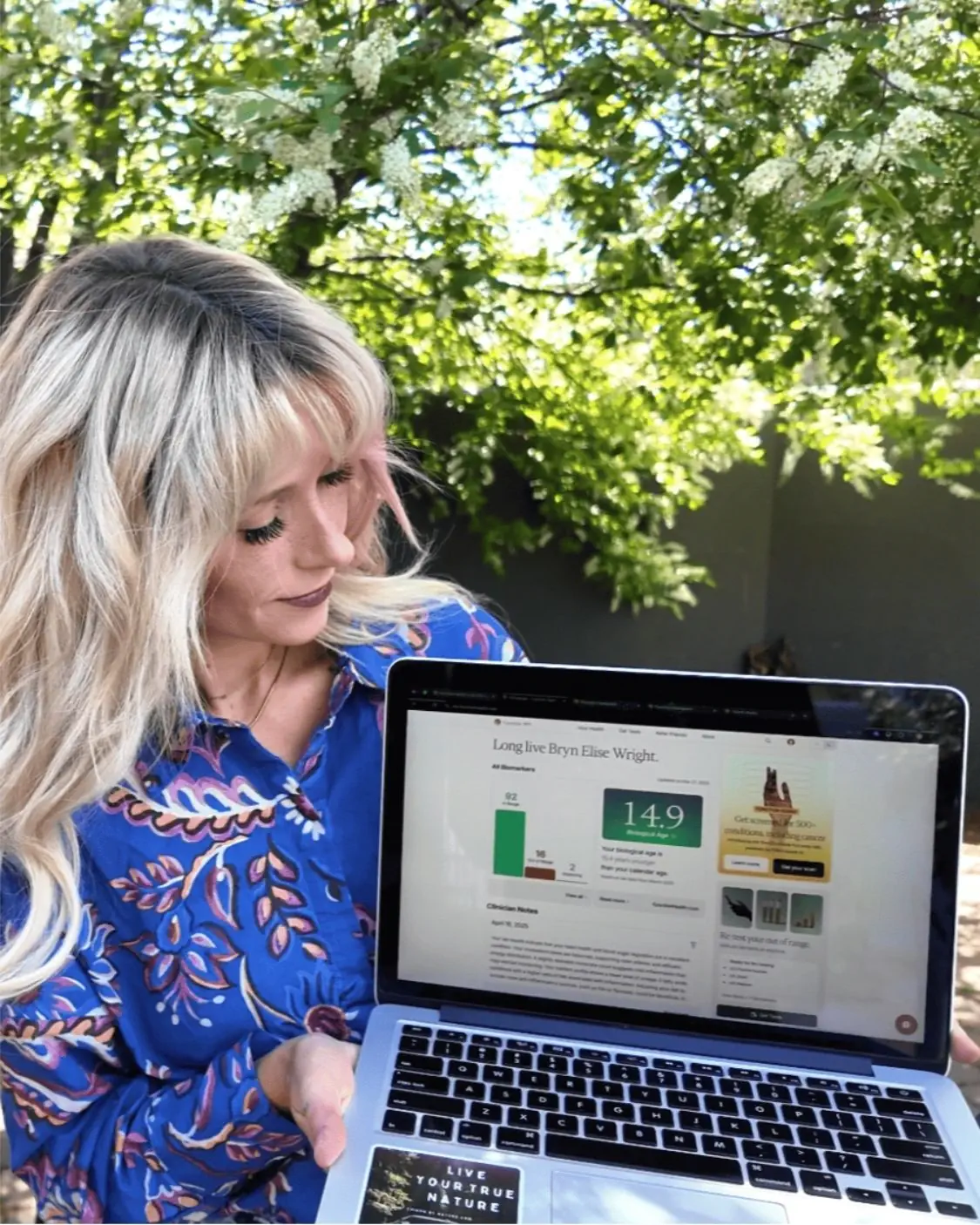 Woman reviewing Function Health biomarker results on a laptop, showing 92 in range, 16 out of range, and organ health score, highlighting affordable preventive health scans in America.