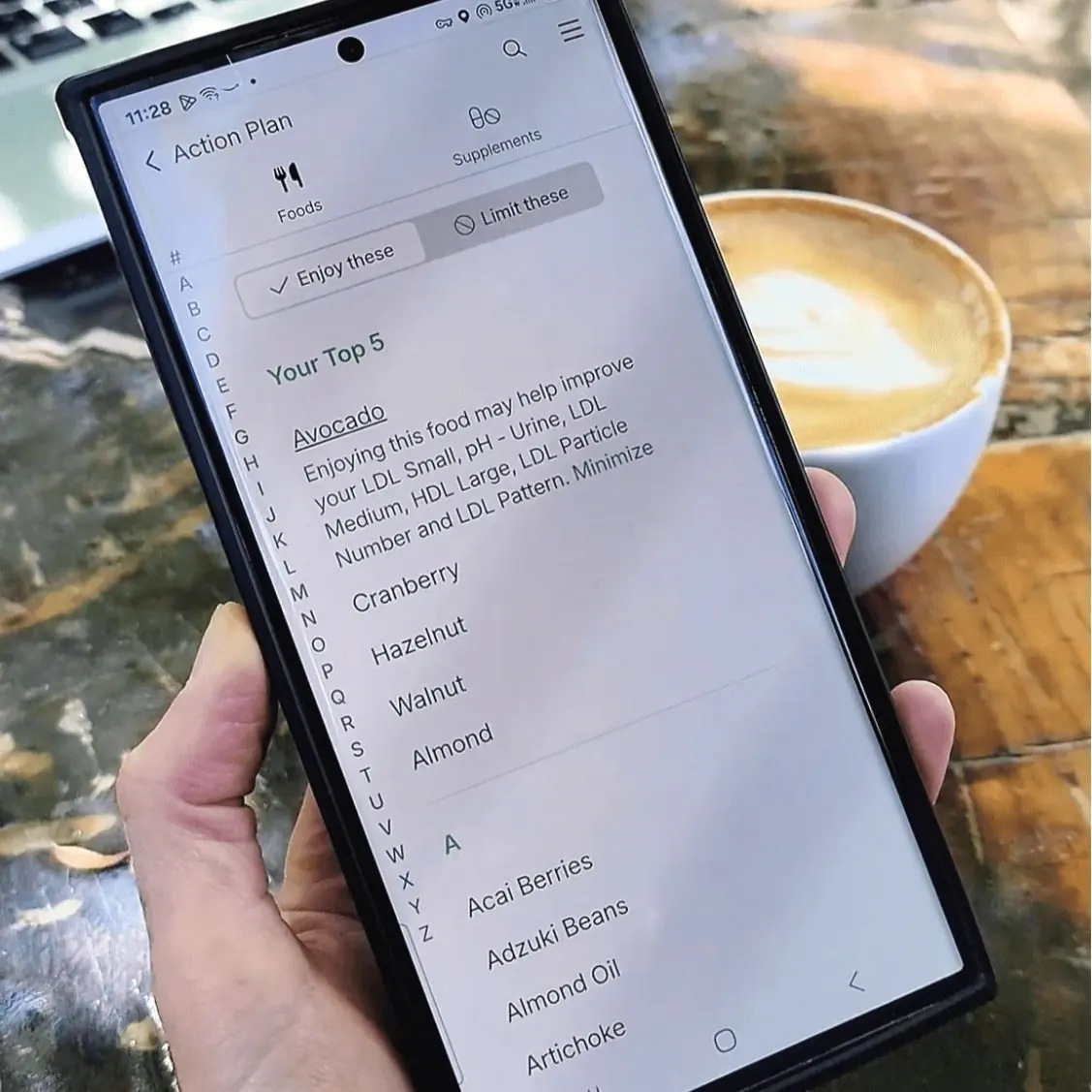 Smartphone screen showing Function Health action plan with personalized nutrition recommendations, highlighting top foods like avocado, cranberry, hazelnut, walnut, and almond for preventive health optimization in the U.S.