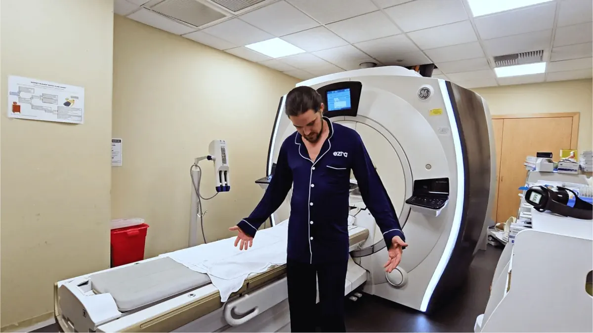 Man in pajamas standing beside MRI machine preparing for a full-body scan at a medical imaging center.