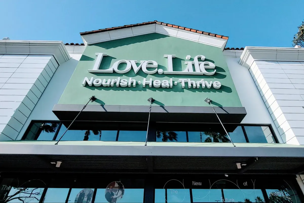 Exterior view of Love.Life wellness center with green signage reading “Nourish · Heal · Thrive.”