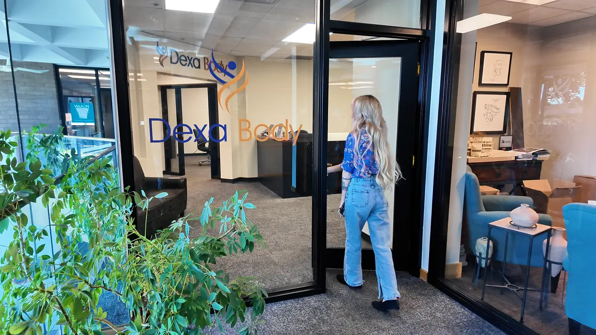Woman walking into the DexaBody clinic, preparing for a body composition analysis and metabolic health testing appointment.