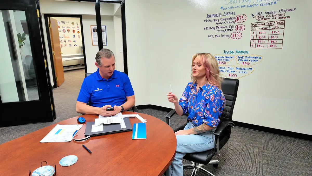 Woman meeting with a DexaBody specialist during a consultation to review metabolic testing options and prepare for a DNA analysis swab.