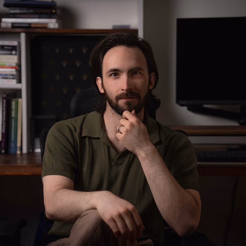 Portrait of Matt Kuper. Man with brown hair, beard, and wearing a dark green polo.