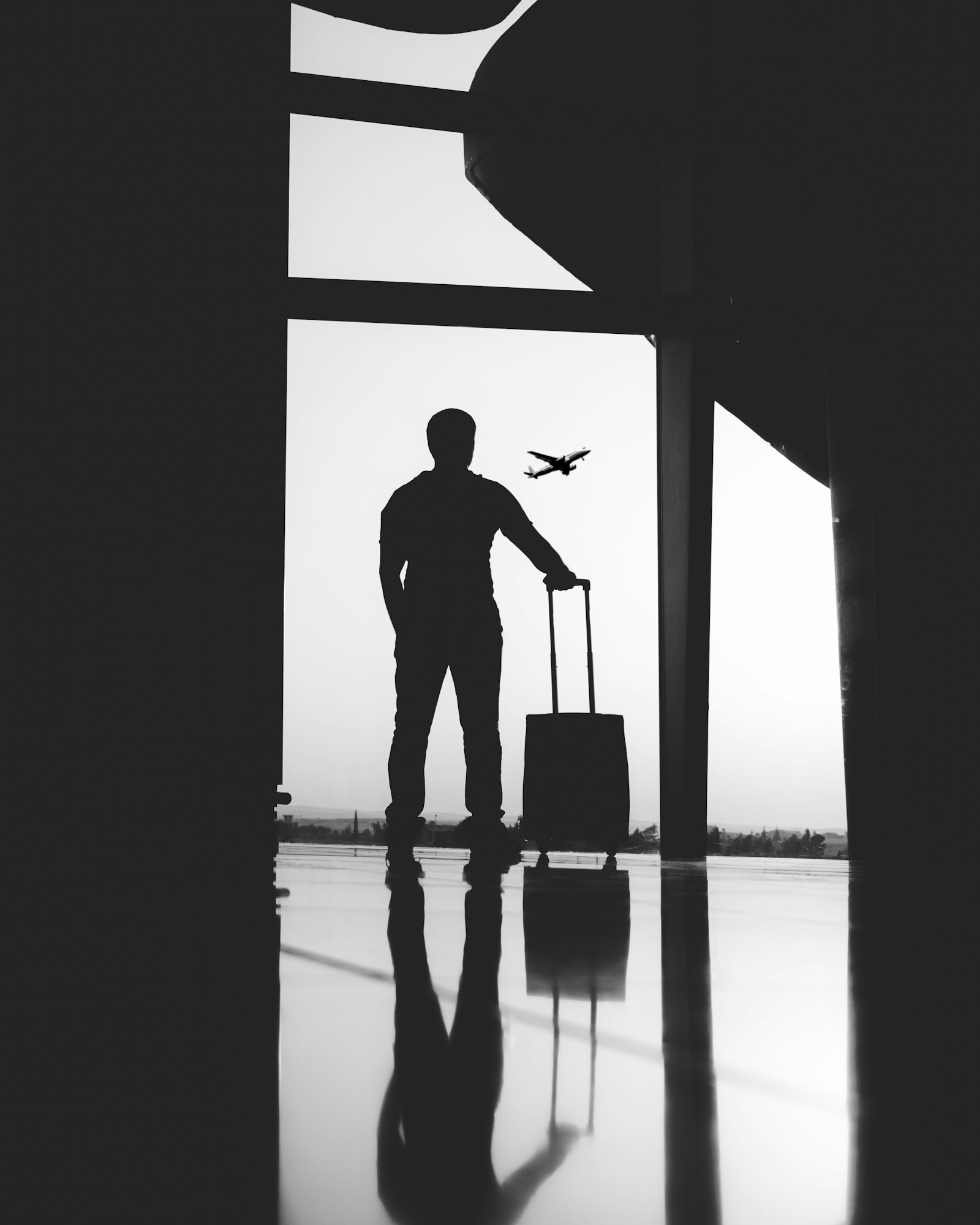 Silhouette of a man holding luggage inside an airport terminal, illustrating extradition from Spain to the United States