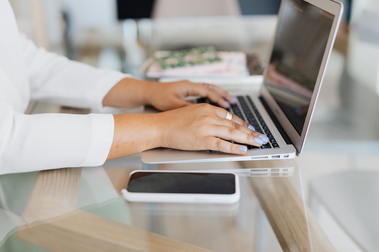 woman sitting at desk writing on laptop