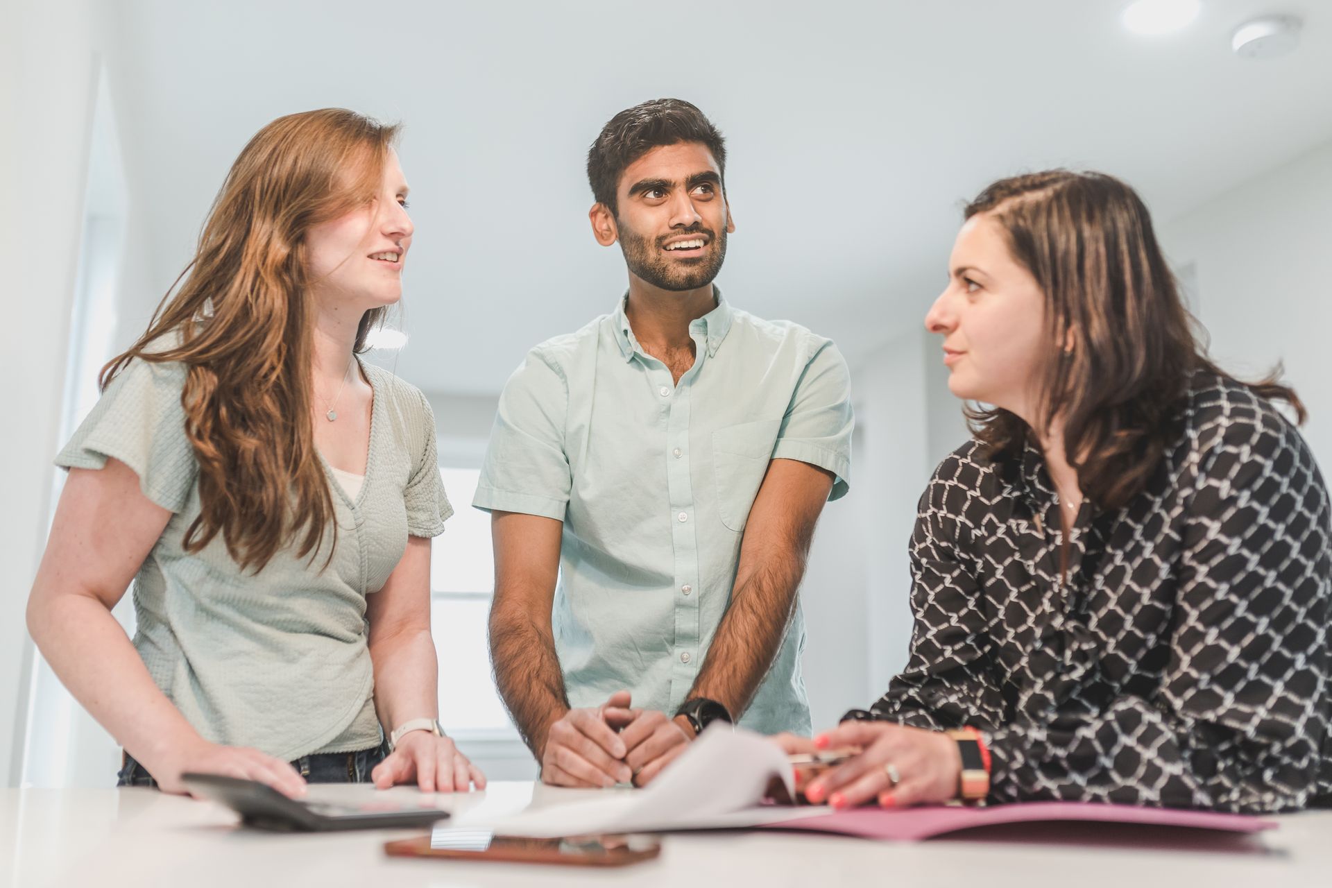 two women and one man talking at a table