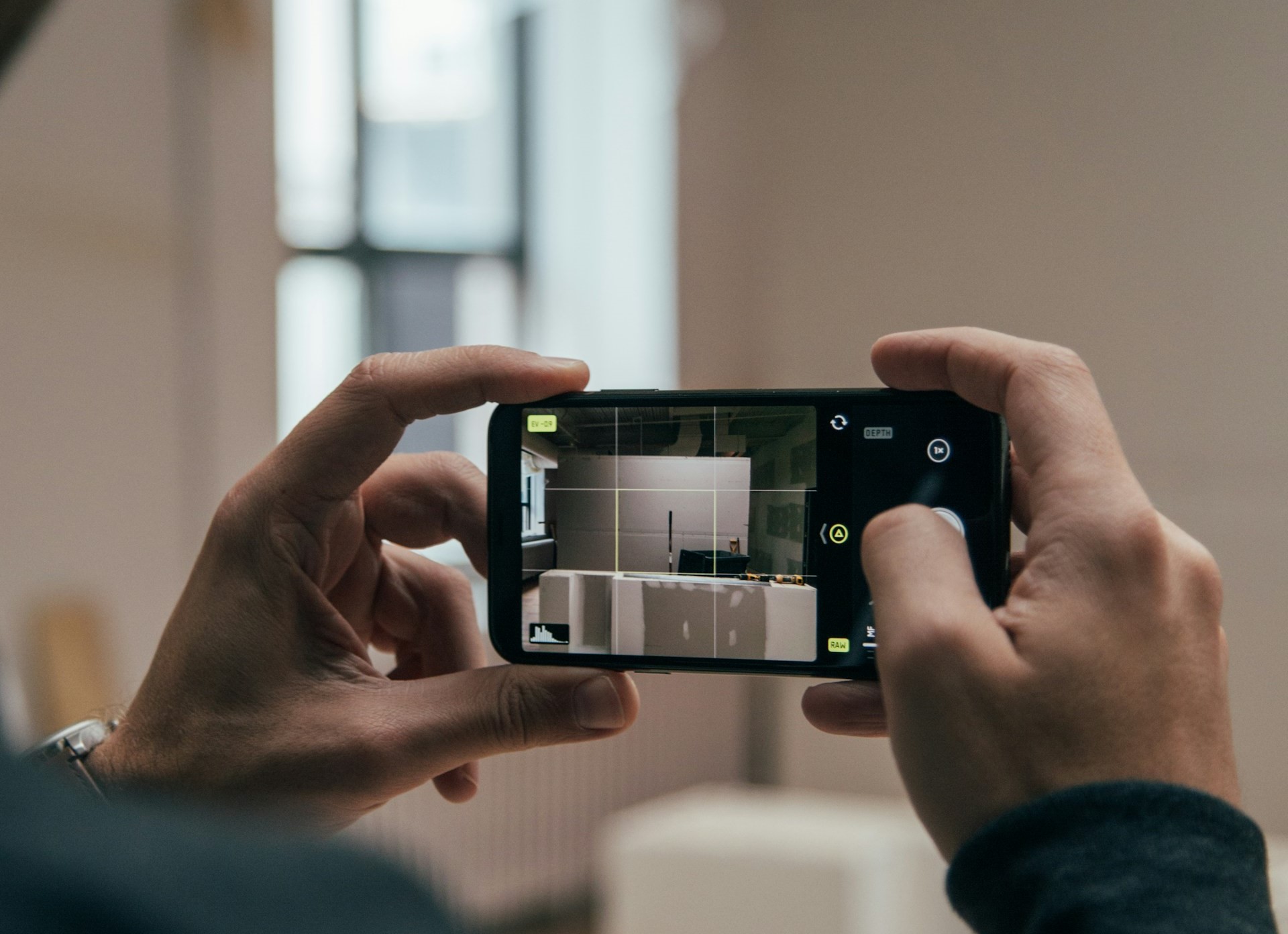 man using a smartphone to take images of a project