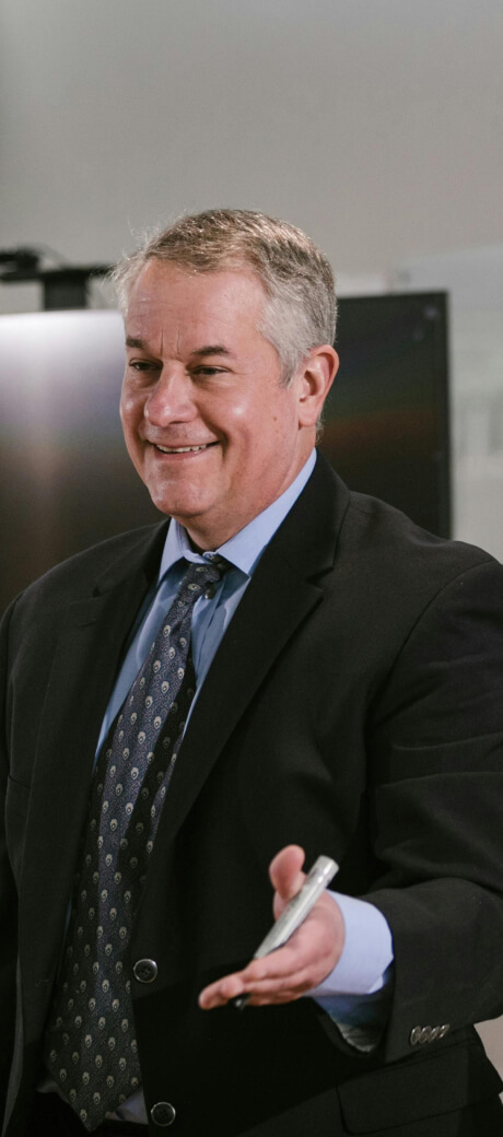Man presenting in suit in 2025, featured on Mackard about us page