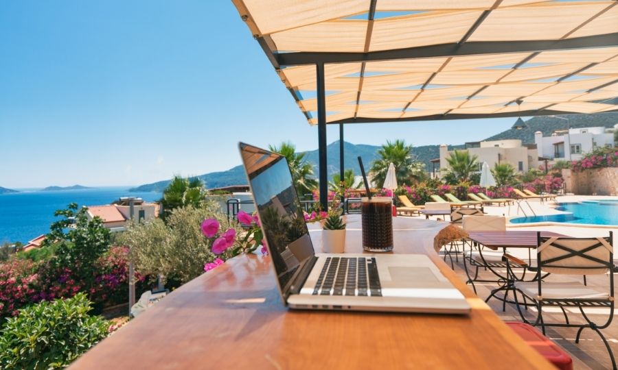 A laptop on a balcony overlooking the sea, showcasing remote AI jobs as future-proof career options for USA professionals.