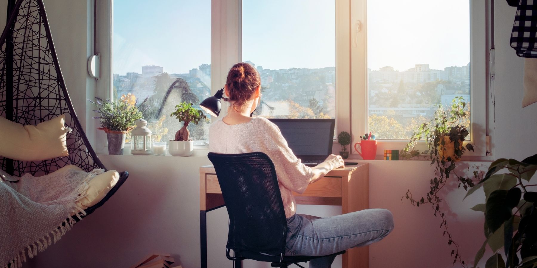 Person working at desk with city view in 2025, pursuing AI-resistant cybersecurity career