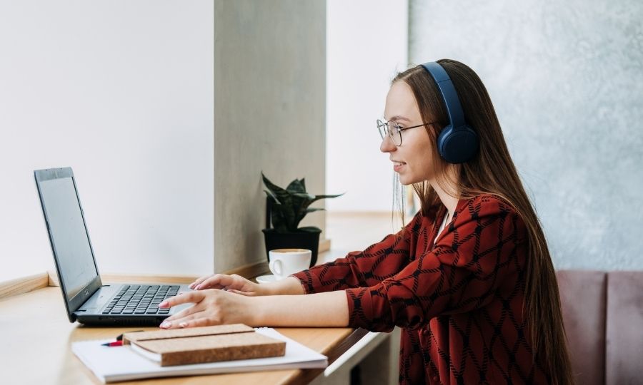 A woman working on a laptop in a bright office, exploring AI-reshaped freelance opportunities for future-proof USA professionals.