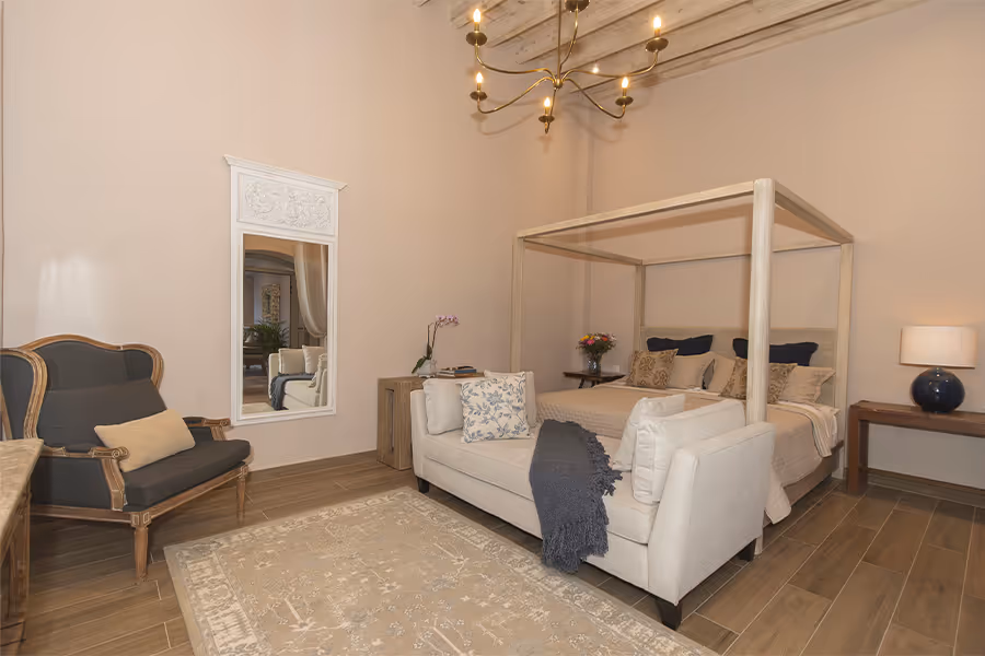 Recamara con cama king size y sofa.