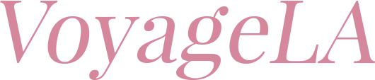 Text logo reading 'VoyageLA' in a serif font with a dusty rose color.