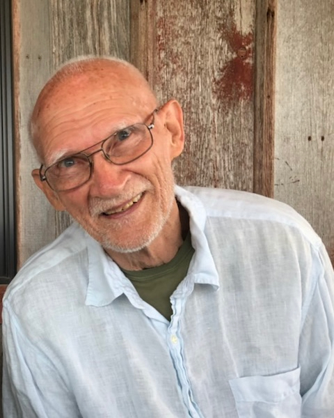 A headshot of Bradford Hansen-Smith. He is close to 80 years old, wearing glasses, bald, and smiling.